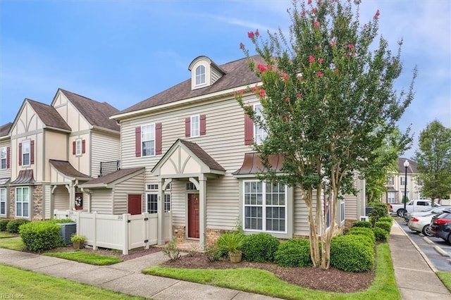 townhome / multi-family property featuring fence, central AC, and roof with shingles