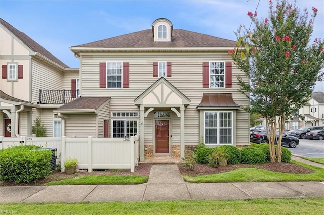 view of front of property featuring a shingled roof and fence