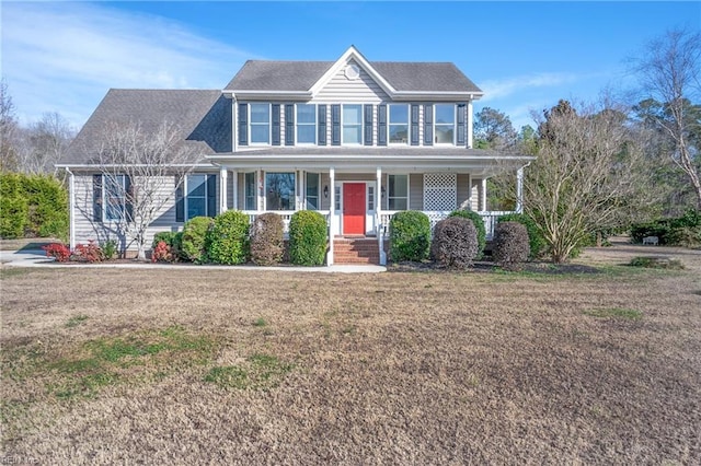 colonial home featuring a porch and a front lawn