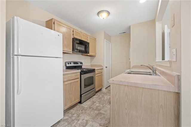 kitchen featuring electric range, black microwave, light countertops, and freestanding refrigerator