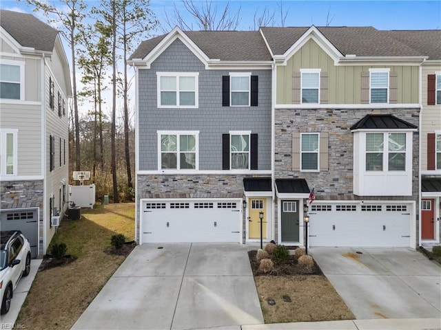 view of front of home with a garage, stone siding, board and batten siding, and concrete driveway