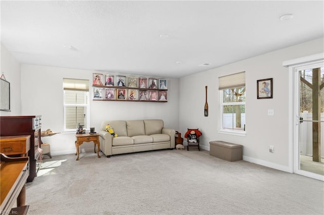 living room with a healthy amount of sunlight, light colored carpet, and baseboards