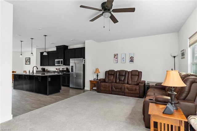 living room featuring a ceiling fan and dark carpet