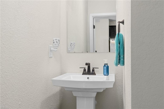 bathroom with a sink and a textured wall