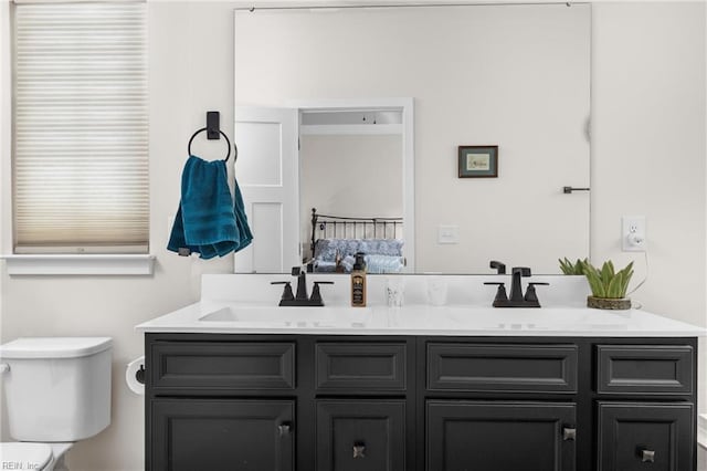 bathroom featuring a sink, toilet, and double vanity