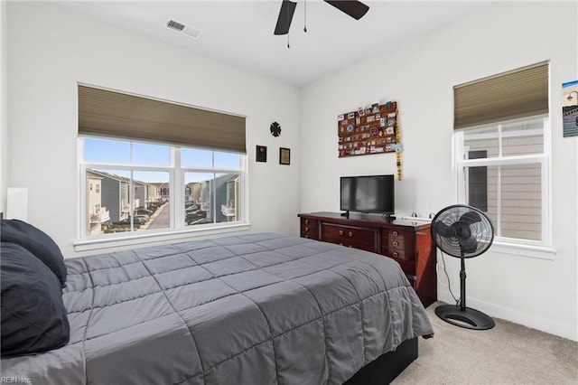 carpeted bedroom with a ceiling fan, visible vents, and baseboards