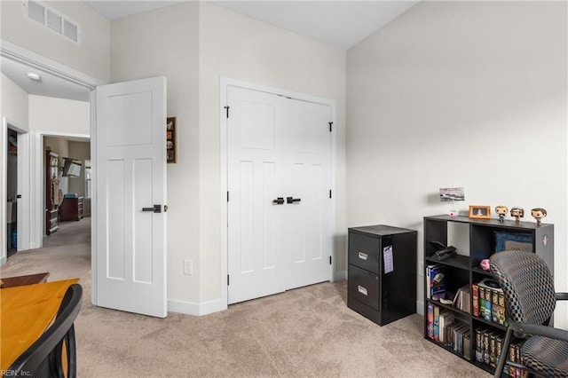 interior space with visible vents, light carpet, and baseboards