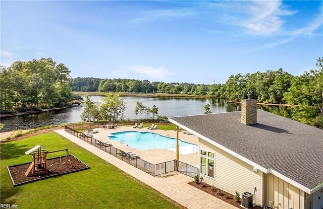 view of pool featuring a water view, a fenced in pool, playground community, and a yard