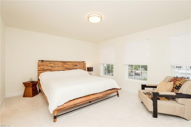 bedroom featuring light carpet and baseboards