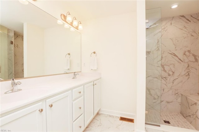 bathroom featuring marble finish floor, a marble finish shower, visible vents, and a sink