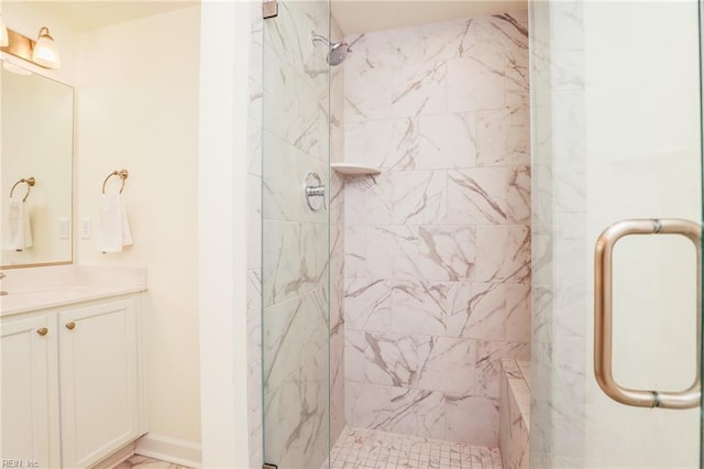 bathroom featuring a stall shower, vanity, and baseboards