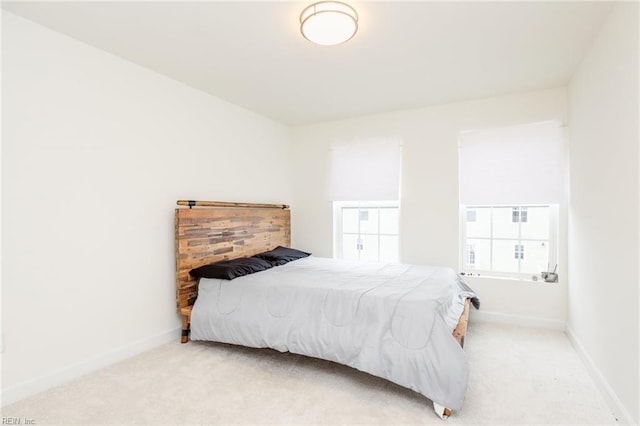 bedroom with light carpet and baseboards