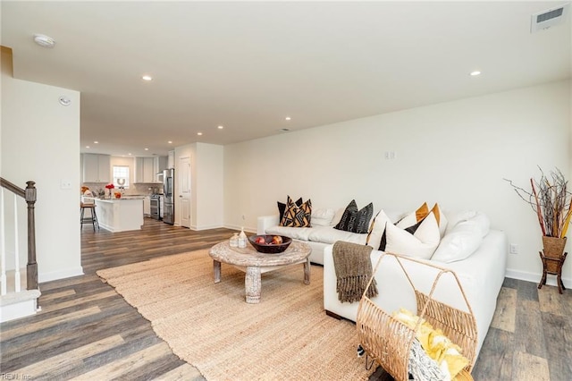 living area with dark wood-style floors, stairway, and recessed lighting