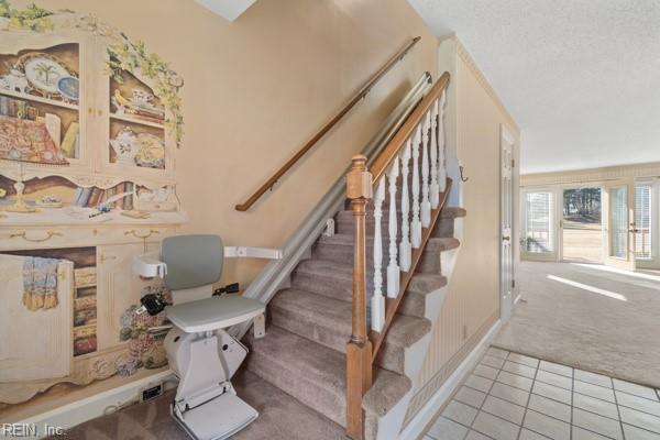 stairs featuring carpet and tile patterned flooring