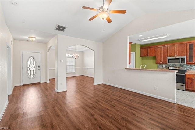 interior space featuring visible vents, arched walkways, a ceiling fan, lofted ceiling, and wood finished floors