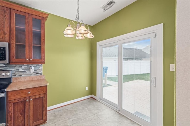 interior space featuring visible vents, baseboards, and an inviting chandelier