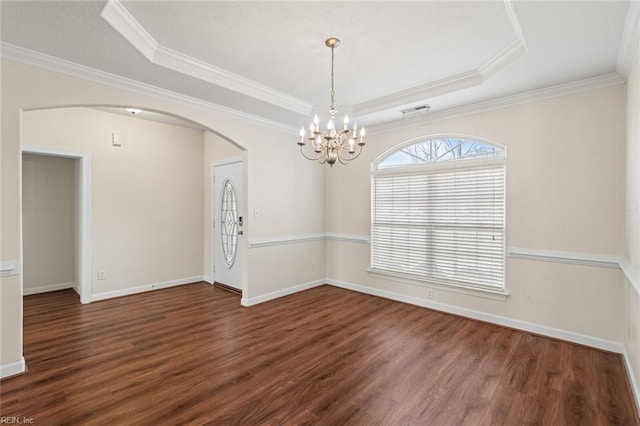 empty room featuring visible vents, arched walkways, ornamental molding, dark wood-style flooring, and a tray ceiling