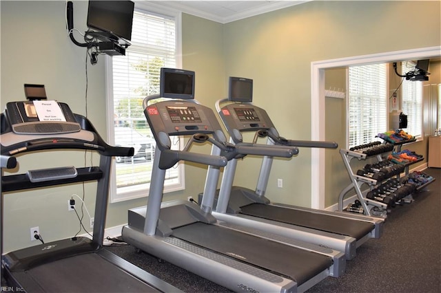 exercise room with ornamental molding and baseboards