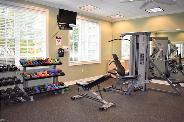 exercise room featuring baseboards and crown molding