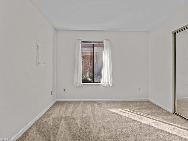 unfurnished room featuring carpet floors and baseboards