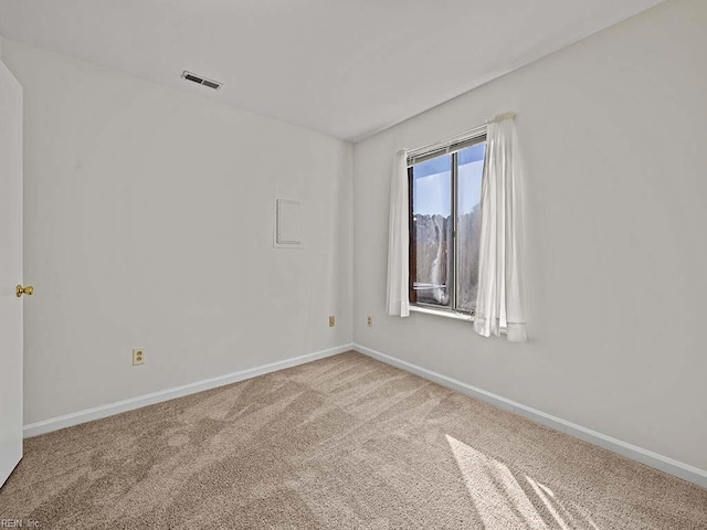 unfurnished room featuring carpet, visible vents, and baseboards