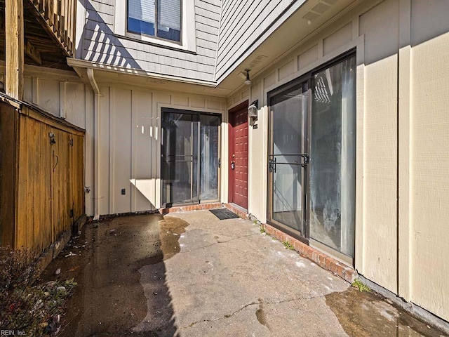 exterior space with board and batten siding, a patio area, and fence