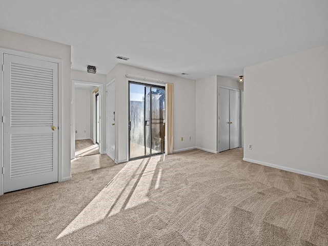 spare room featuring visible vents, baseboards, and light colored carpet