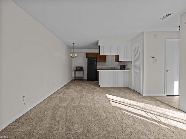 unfurnished living room featuring a chandelier, light carpet, a sink, visible vents, and baseboards