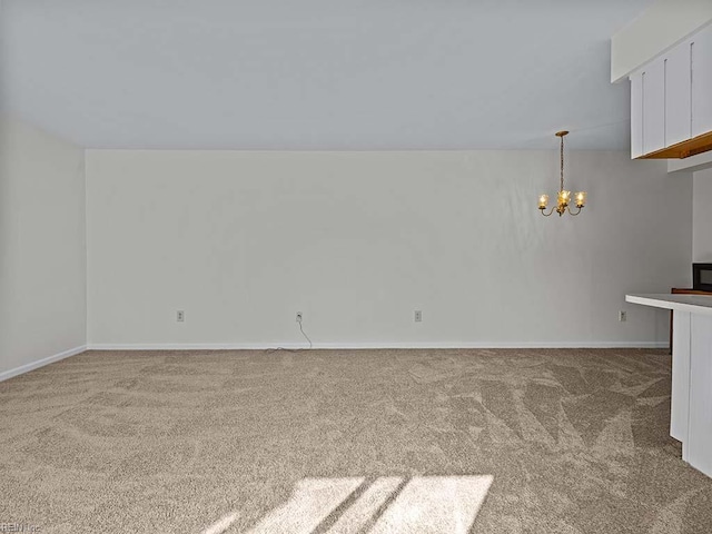 unfurnished living room featuring a chandelier, light carpet, and baseboards