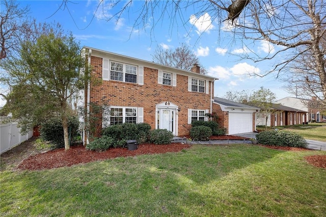 colonial home with a front yard, fence, brick siding, and a chimney