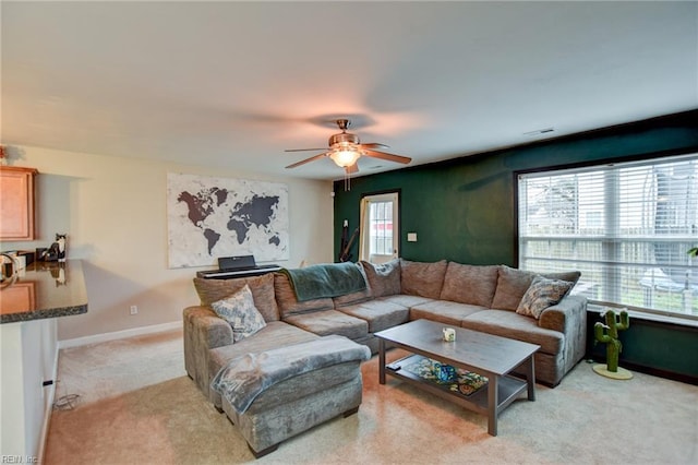 living room featuring light carpet, visible vents, baseboards, and a ceiling fan