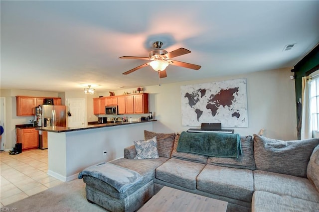 living room with ceiling fan, light tile patterned flooring, visible vents, and baseboards