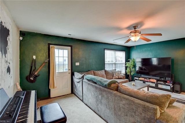 living room with ceiling fan, visible vents, and light colored carpet