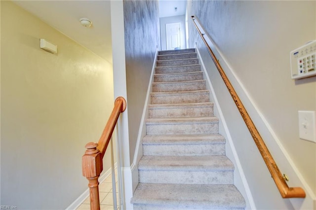 staircase featuring baseboards and tile patterned floors