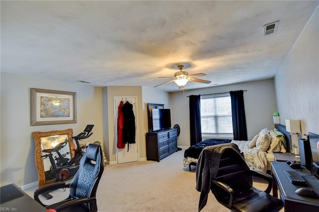 bedroom with light carpet, ceiling fan, visible vents, and baseboards