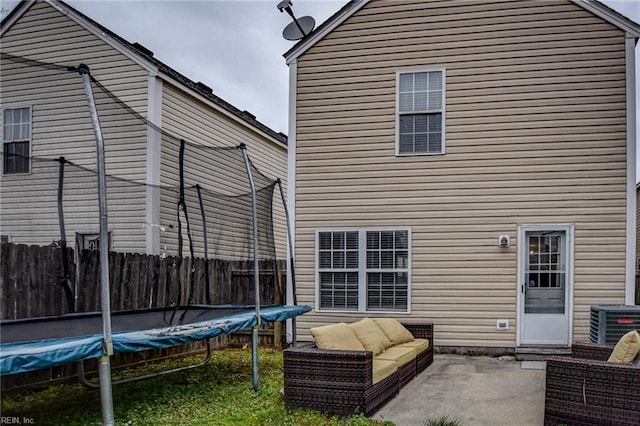 back of house with a patio, a trampoline, fence, and central air condition unit