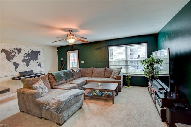 living area featuring light carpet, ceiling fan, and baseboards