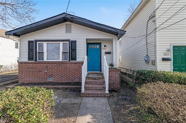 view of front of property with crawl space and brick siding