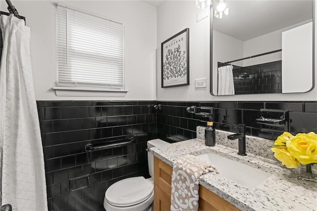 full bath with wainscoting, toilet, a shower with curtain, vanity, and tile walls