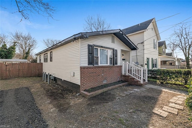 exterior space with crawl space, fence, and brick siding