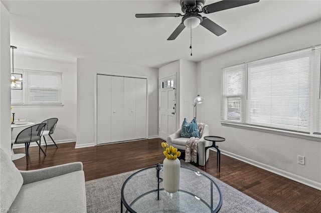 living room featuring a ceiling fan, baseboards, and wood finished floors