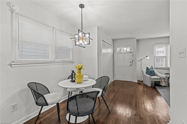 dining space with an inviting chandelier, wood-type flooring, and baseboards