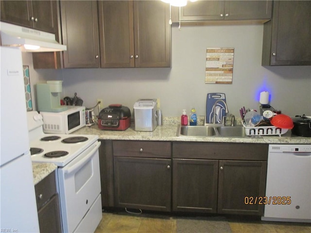 kitchen with light countertops, a sink, dark brown cabinets, white appliances, and under cabinet range hood