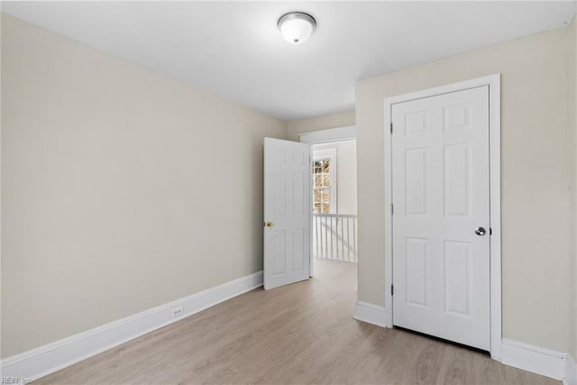 unfurnished room with light wood-type flooring and baseboards