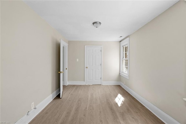 empty room featuring light wood-style floors and baseboards