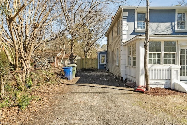 view of side of home with driveway and fence