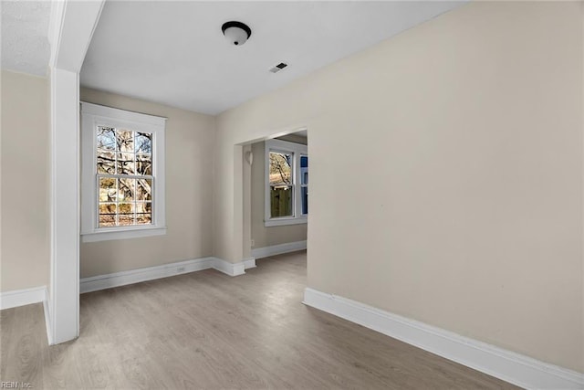 unfurnished dining area with light wood-type flooring, visible vents, and baseboards