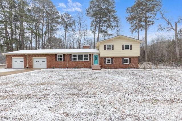 tri-level home with entry steps, brick siding, and an attached garage