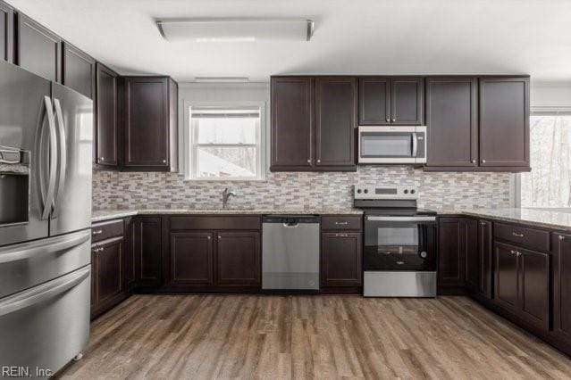 kitchen with plenty of natural light, appliances with stainless steel finishes, light countertops, and decorative backsplash