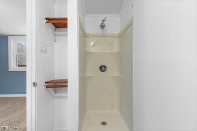 bathroom featuring a shower stall and baseboards